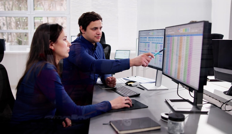 Automate AR and AP to Improve Cash Flow in 30 Days Two manufacturing professionals reviewing automated AR and AP dashboards to improve cash flow efficiency