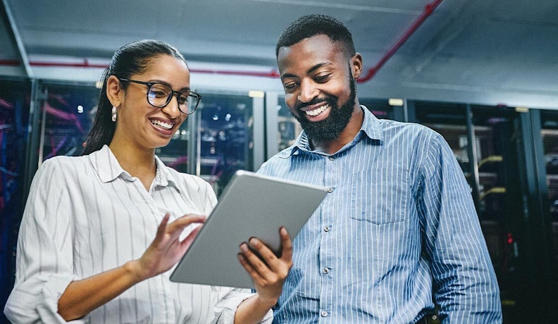 Why Cloud Solutions are Crucial for Manufacturing Survival Two tech workers (man and woman) reviewing cloud solutions on their mobile tablet