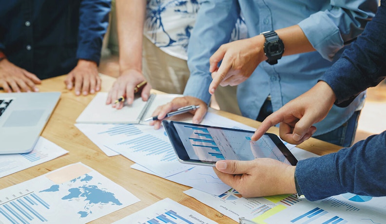 Exponential Mindset in Field Service: Data-Driven Collaboration Team analyzing service performance data on a tablet and printed reports, illustrating an exponential mindset in field service operations.