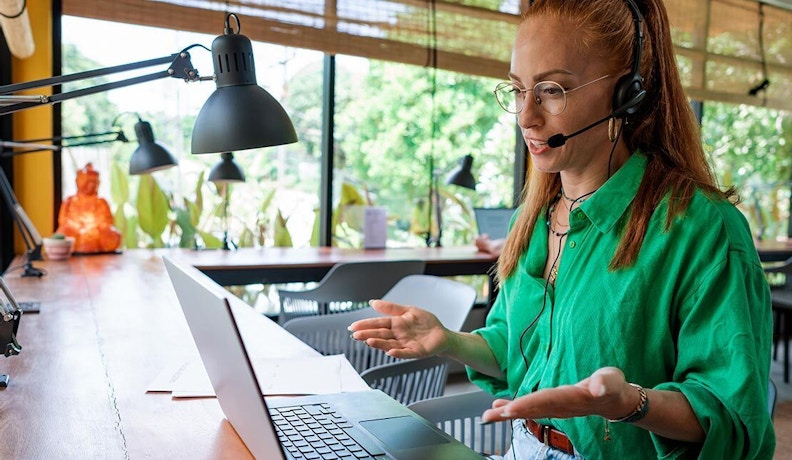 How to Measure Customer Experience Consultant on a computer talking to a customer