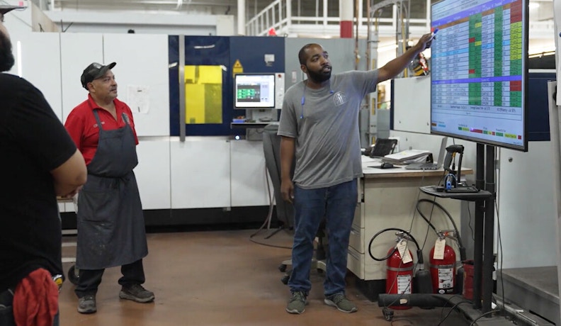 Reducing downtime and optimizing Manufacturing Efficiency with Alora Manufacturing technicians reviewing performance data