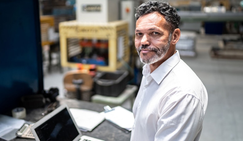 Reviewing manufacturing performance to support growth decisions Manufacturing manager reviewing production and performance data on the factory floor