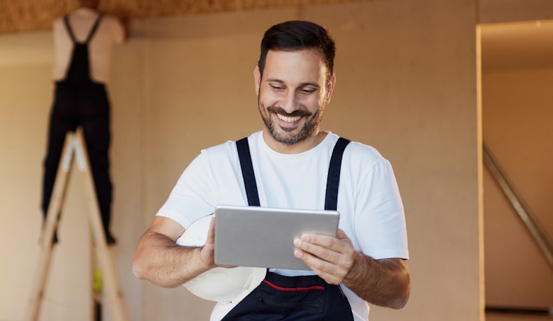 QuickBooks Online Integration for Construction Teams Construction worker using tablet to access QuickBooks Online integration on-site
