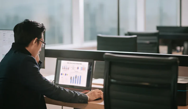 AI Analytics Dashboard for SMB Operations Business owner reviewing AI analytics dashboard on laptop in office