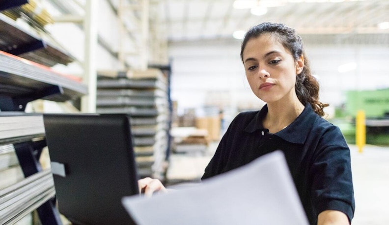 AI BOM Builder Lady reviewing paperwork in a high-tech office.