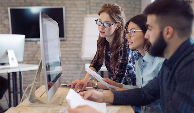 Guide to ERP Systems Office tech workers reviewing data