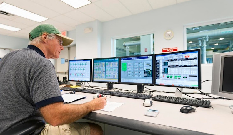 How ECI MES Helps Job Shops Maximize Efficiency Job shop manager reviewing data on multiple computer screens