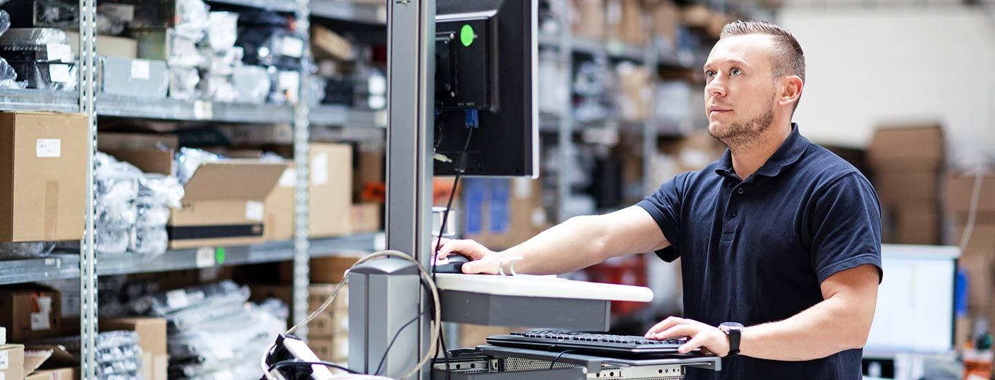 Job Shop ERP Guide2023 5 Header A job shop worker using a computer