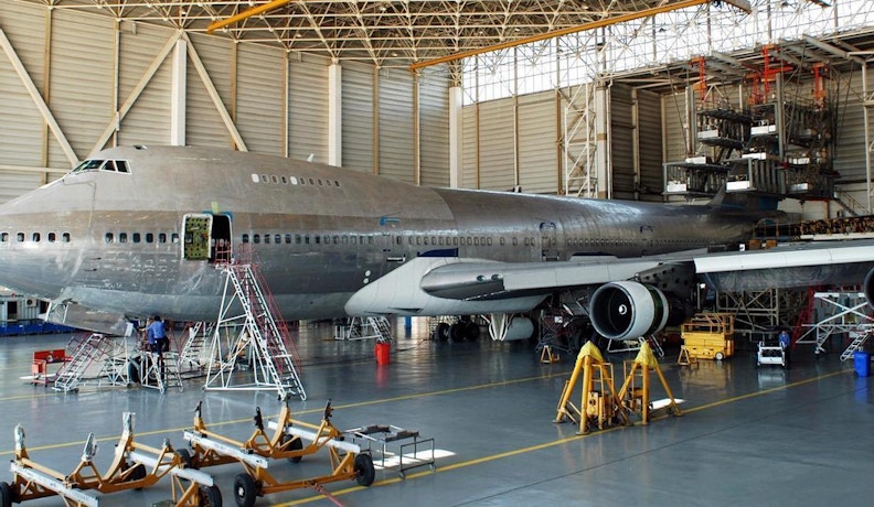 Aerospace manufacturing software Mechanical work being completed on a large airplane