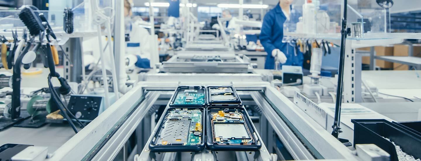 ERP Software for Electronics Manufacturers on Assembly Line Electronics assembly line with circuit boards, illustrating ERP software benefits for electronics manufacturers.
