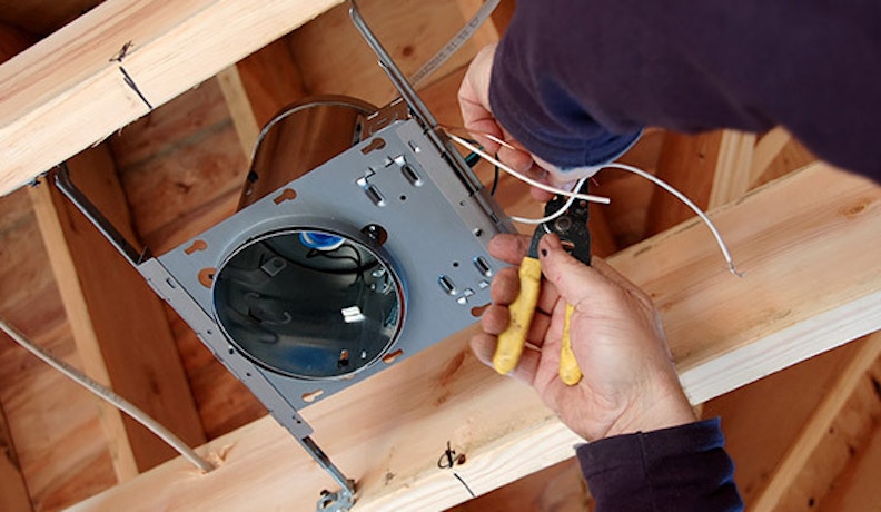 Mobile Software for Electrical Contractors Electrical contractor installing a light fixture in new home construction