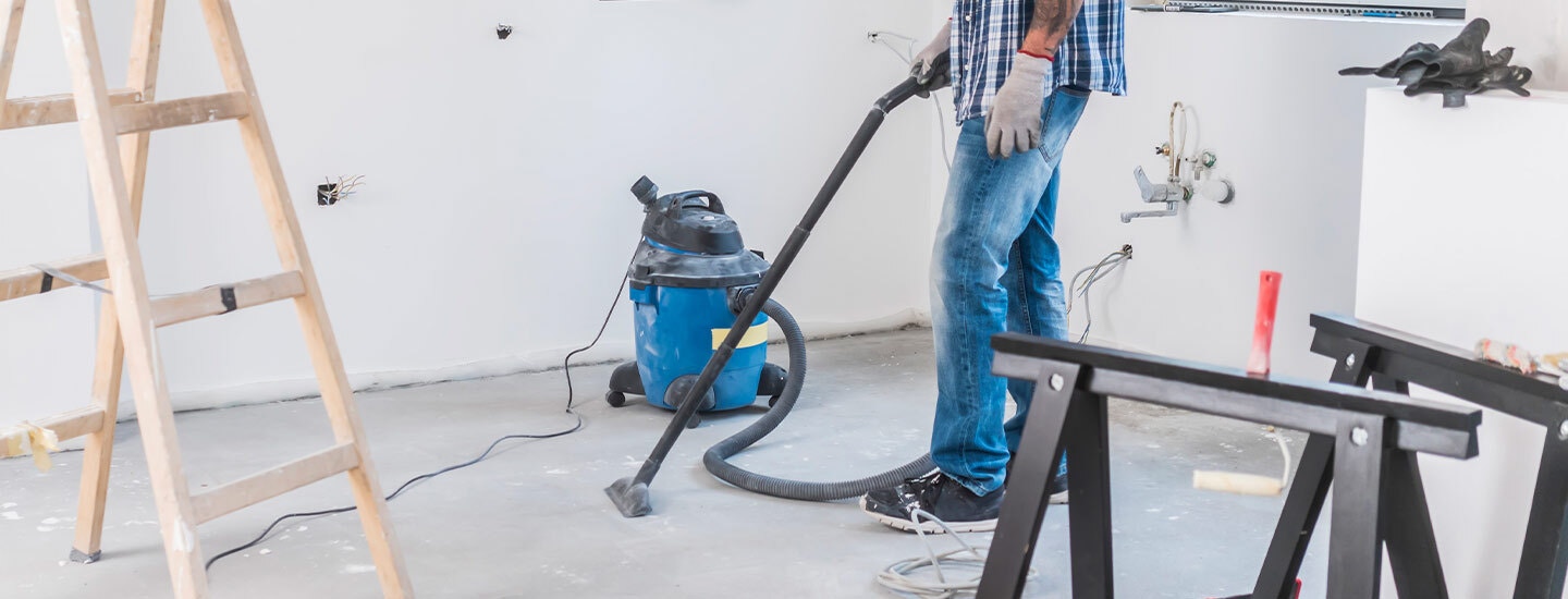 Cleaning contractor vacuuming a room in new home construction