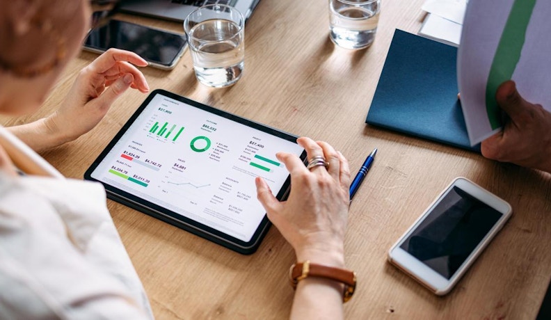 Alora data visualization for employee satisfaction A manufacturing expert visualizing data from Alora using a tablet.