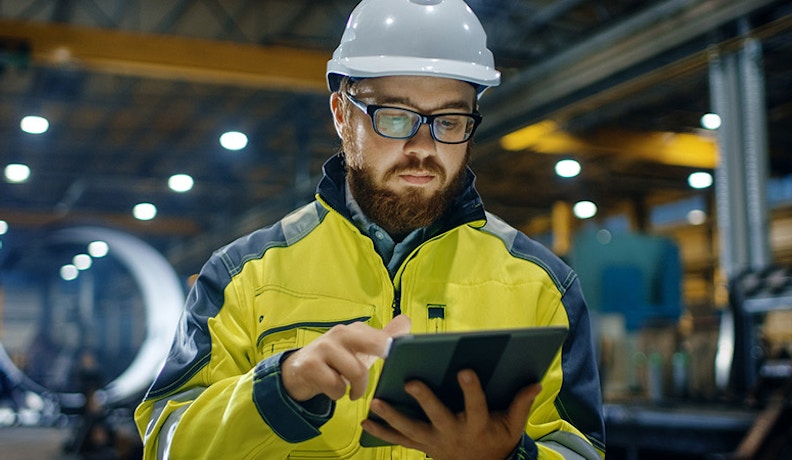 Benefits man in hard hat looking at tablet