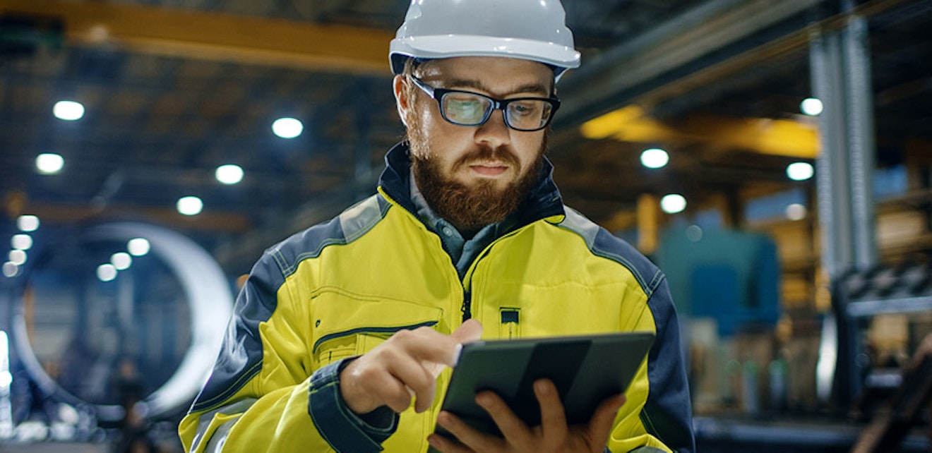 man in hard hat looking at tablet