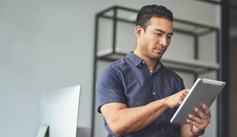 Best ERP for Customer Experience on Tablet Interface Man using a tablet to access ERP software, improving customer experience through digital tools.
