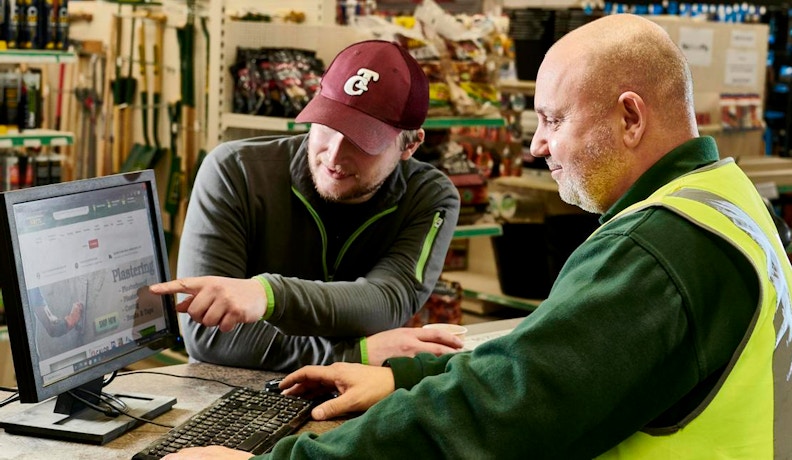 Boost DIY Search Traffic for Your LBM Business Lumber and Hardware store attendance conversing with a customer at the checkout register