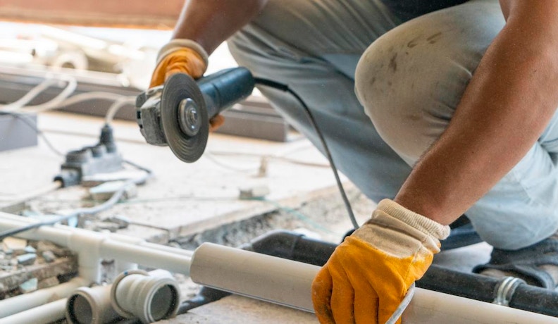 Bolt Trade Contractor Software Plumber cutting PVC pipe in new home construction