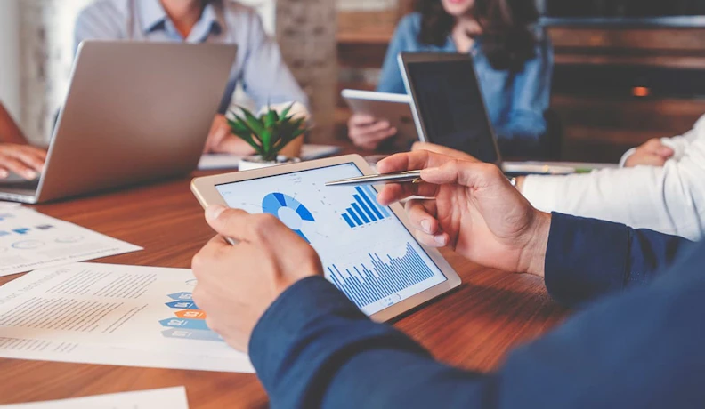 Man looking at analytics for business decision Man working on tablet looking at AI solutions for his business